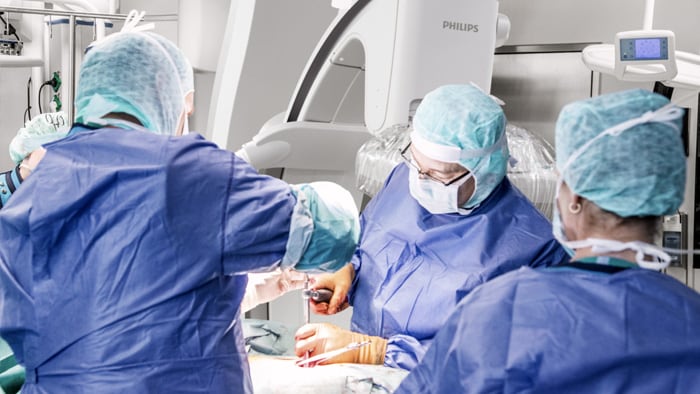 Chirurgen kijken naar het scherm en bespreken hoe ze verder moeten gaan met de operatie aan de wervelkolom