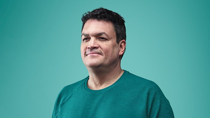 Afbeelding van een glimlachende man in groen t-shirt
