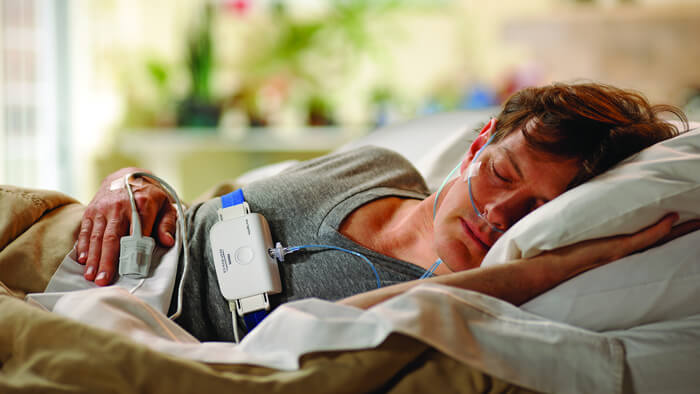 Foto van een man in bed die op zijn zij slaapt tijdens een Philips-slaaptest