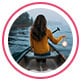 Profielfoto van recensente, een vrouw die op roeiboot zit en een peddel vasthoudt, met het gezicht naar de zee.