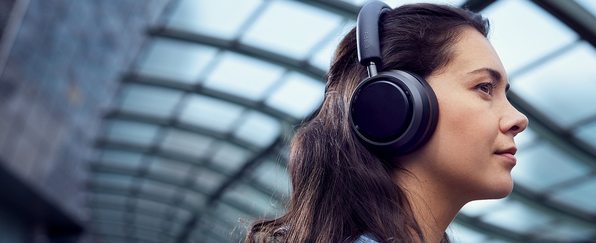 Vrouw geniet van muziek tijdens reizen en gebruikt Philips L4 koptelefoon