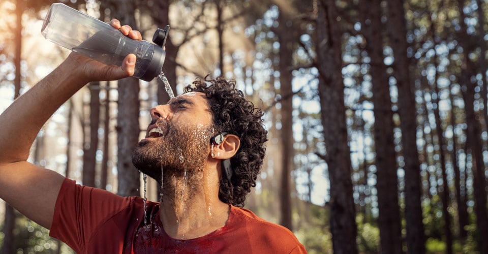 Sporter die water over de waterdichte open-ear koptelefoon giet