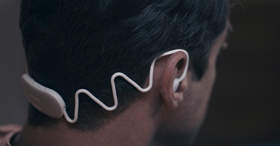 Afbeelding van Philips Sleep Headphones die strak, maar comfortabel, om het hoofd van een man passen.