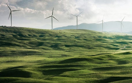 Een windmolenpark met groene heuvels, om schone energie en duurzaamheid in bedrijven voor te stellen