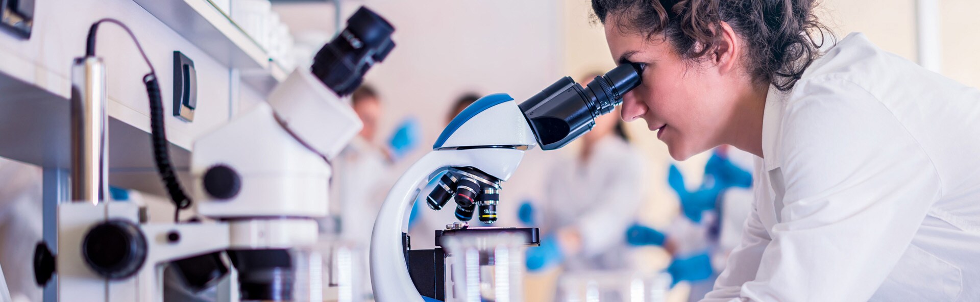 A researcher looking into a magnifier