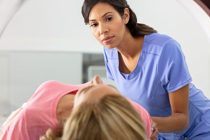 Radiology technologist guides patient (opent in een nieuw tabblad)