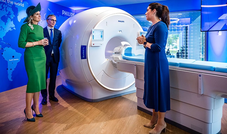 Hare Majesteit Koningin Máxima en Philips-CEO Roy Jakobs krijgen een demonstratie bij een BlueSeal MRI-systeem, een innovatie die wereldwijd de toegang tot diagnostische beeldvorming vergroot en het heliumverbruik vermindert.