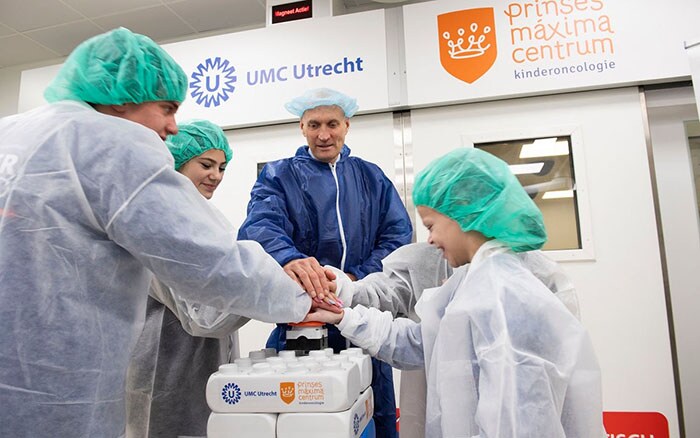 mensen gekleed in operatie kleding die op een grote rode knop drukken