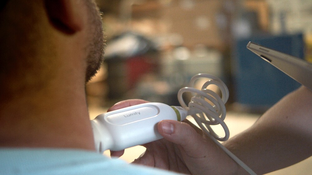 Een verpleegster voert een mobiele echoscopie uit bij een patiënt