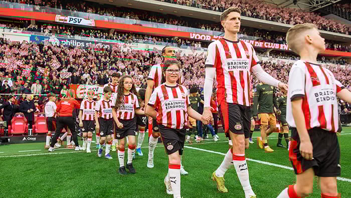 De liefde voor rood-wit doorgegeven: Kinderen van Philips-medewerkers met spelers van PSV het veld op